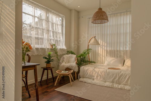 Warm and cozy room interior, bedding and pillows, sunlight and shadows on the curtains