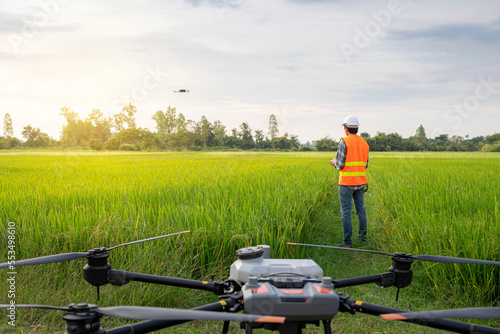 Agricultural specialist controls agriculture drone with remote controller for survey and data analysis data in rice fiel. Agriculture 5g, Smart farming, Smart technology concept. photo