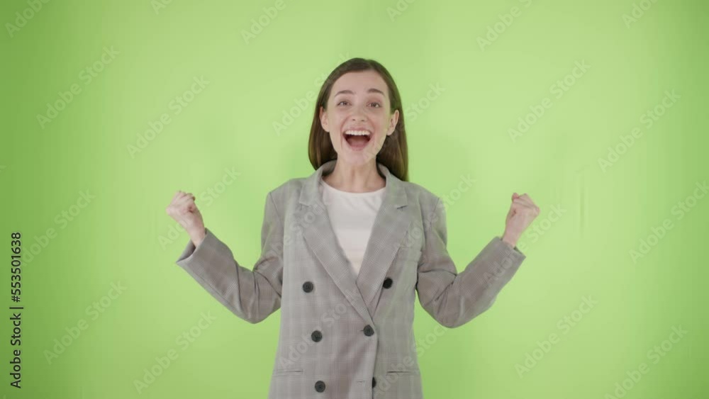 Surprised joyful young business woman which say wow spreading hands on green background in studio Surprised joyful young business woman which say wow spreading hands on green background in studio
