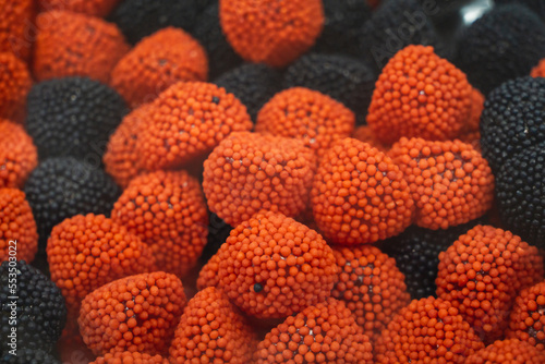 Balas e Doces Vermelhas e Pretas em formato de morangos e framboesas. photo