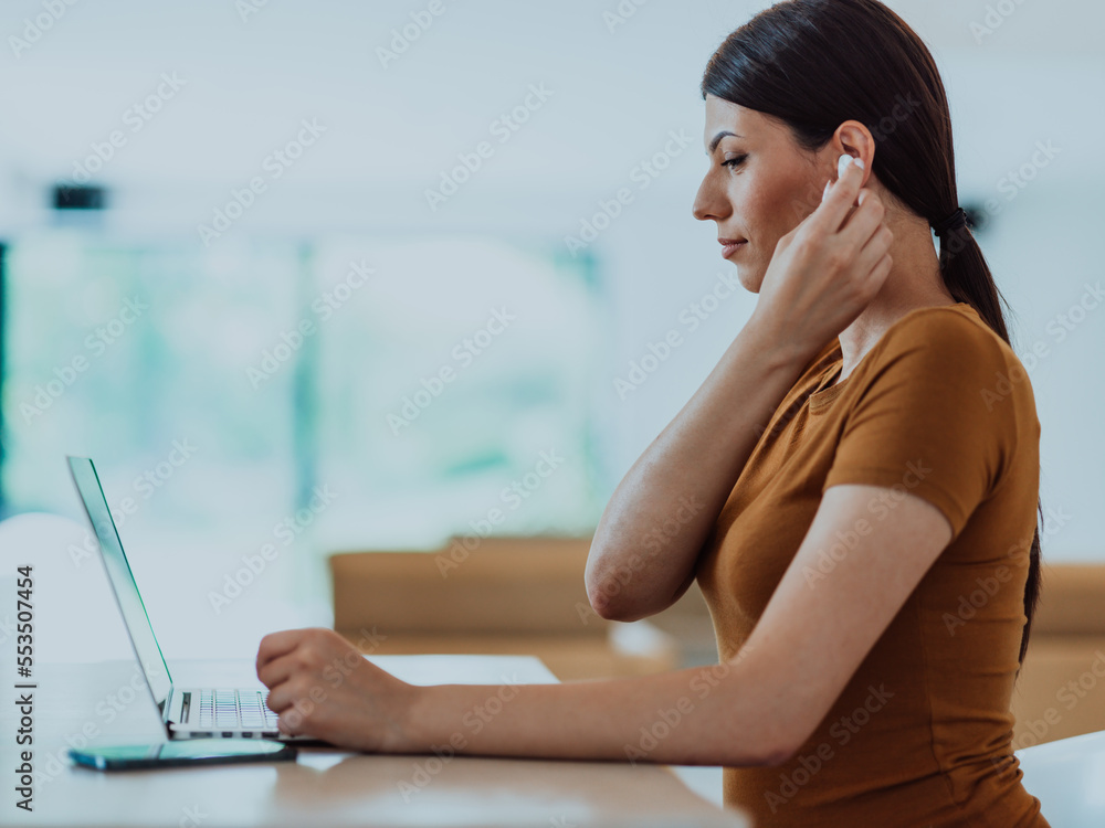 Obraz premium Woman sitting in living room using laptop look at cam talk by video call with business friend relatives, head shot. Job interview answering questions.