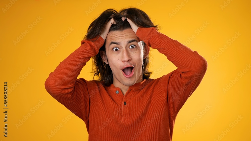 Excited jubilant overjoyed gender fluid non binary man 20s wears orange shirt doing winner gesture celebrate isolated on yellow background studio portrait Excited jubilant overjoyed gender fluid non binary man 20s wears orange shirt doing winner gesture celebrate isolated on yellow background studio portrait