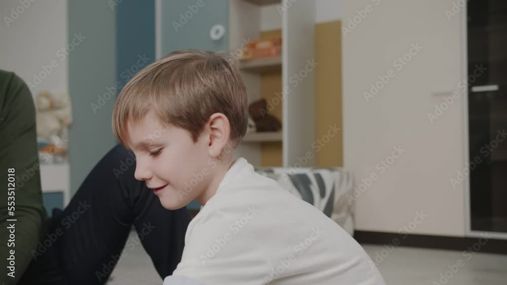 The grandson plays with his grandfather in toys. Builds a constructor. The boy is playing at home. Cute emotions in the frame. The story of one family. The grandson plays with his grandfather in toys. Builds a constructor. The boy is playing at home. Cute emotions in the frame. The story of one family.