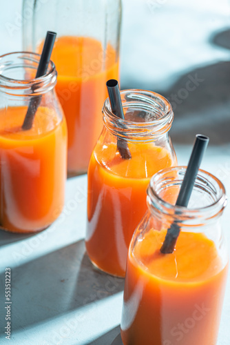 Fresh carrot, orange, apple and ginger juice in glass. 