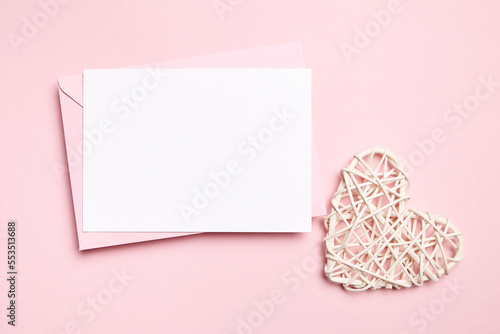 Card mockup, empty Valentines Day love letter with white heart on light pink background, top view, flat lay. Blank wedding invitation, white holiday greeting card © mikeosphoto