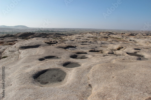 Flat volcanic plateau with small hills and pits in the Bektau-Ata tract, distant view of the valley to the horizon, panorama