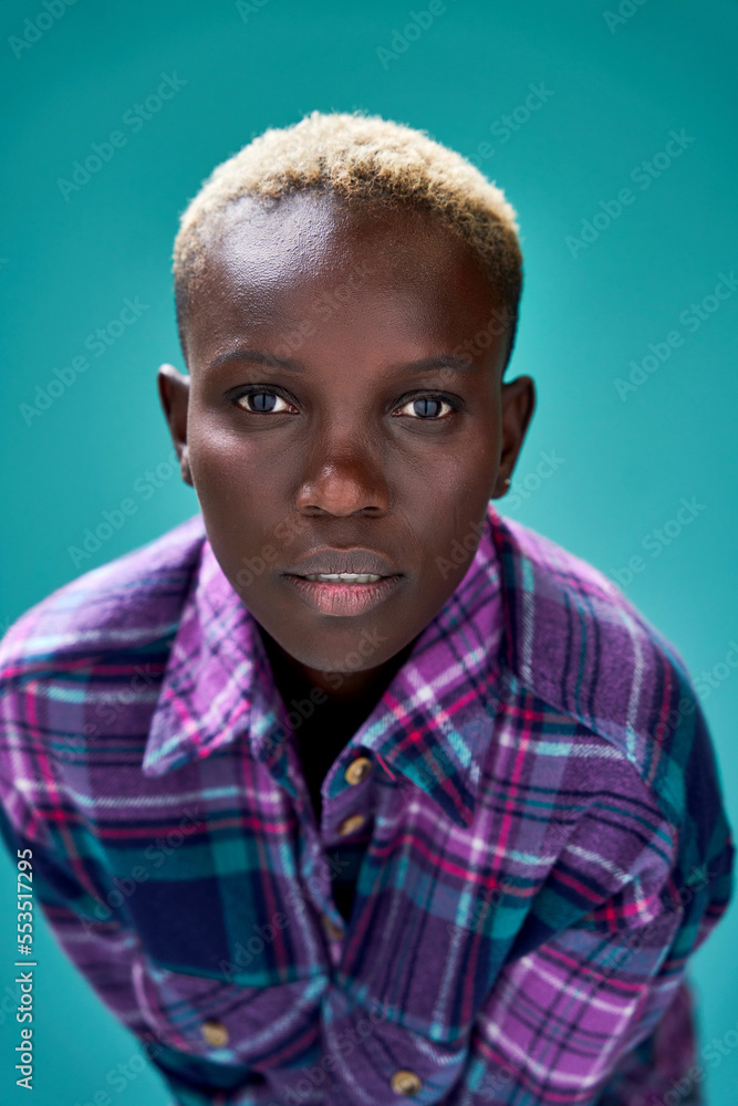 Black woman with blond short hair against turquoise background Black woman with blond short hair against turquoise background