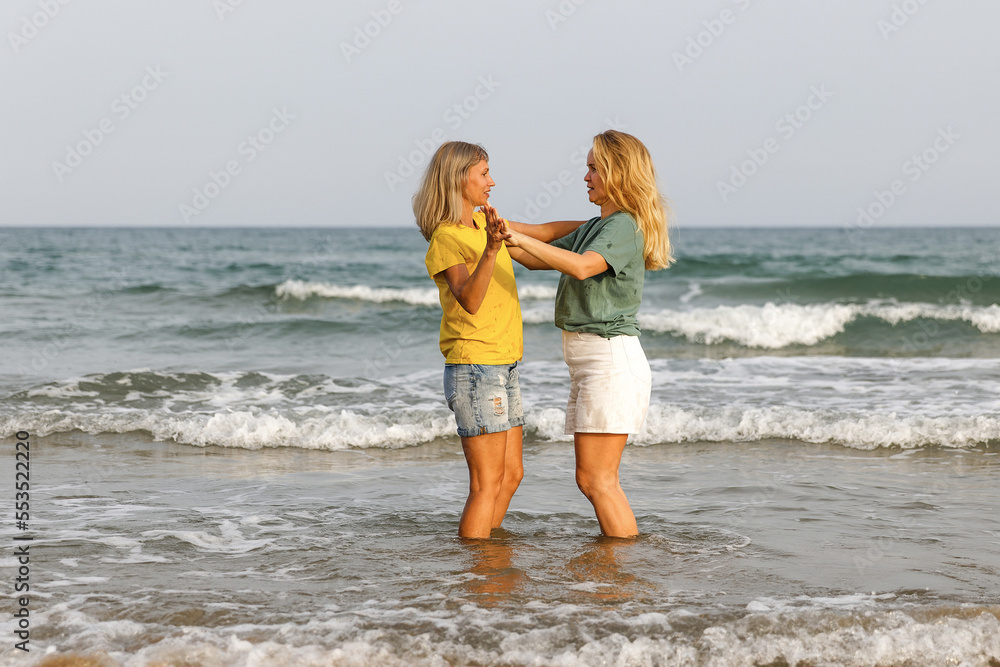 Girlfriends walk and have fun at the sea, family vacation at sea