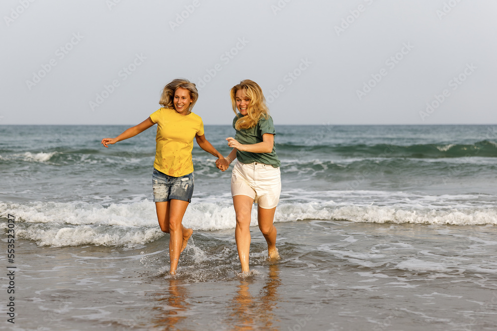 Girlfriends walk and have fun at the sea, family vacation at sea