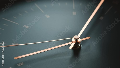 Golden hands of clock are moving slowly on a black face 