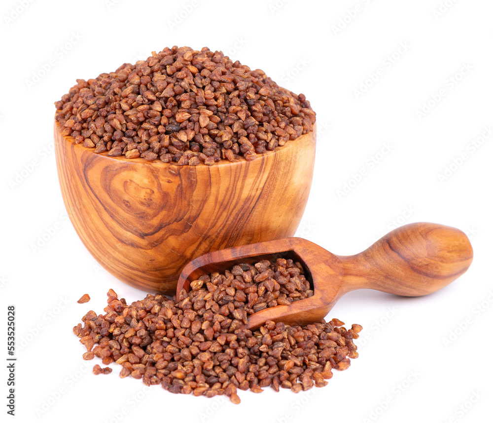 Buckwheat tea in wooden bowl and spoon, isolated on white background. Whole roasted buckwheat grains. Fagopyrum tataricum. Buckwheat tea in wooden bowl and spoon, isolated on white background. Whole roasted buckwheat grains. Fagopyrum tataricum.