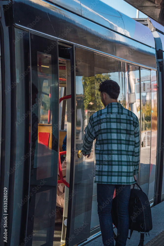 Male student waiting for the tram
