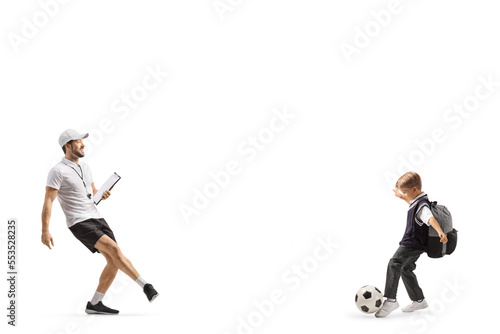 Football coach with a whistle holding a clipboard and training with a schoolboy