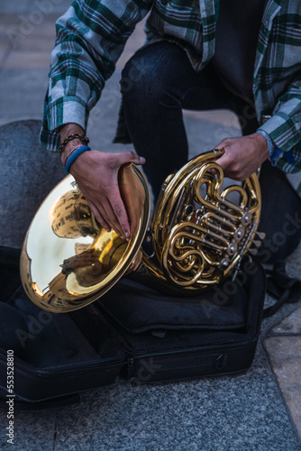 Man riding his horn to play in the street.
