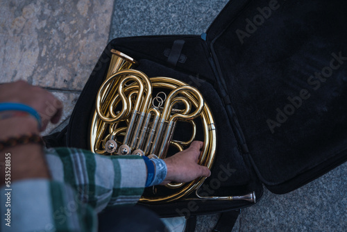 Man riding his horn to play in the street.