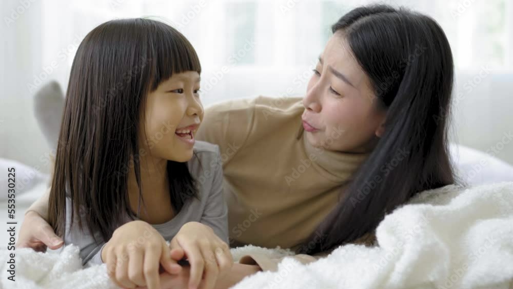 Portrait of happy asian mother little daughter in the bedroom, laughing lying sleep in bed. Mommy and little girl spending time at home. Fun love family woman lifestyle together mother's day concept Portrait of happy asian mother little daughter in the bedroom, laughing lying sleep in bed. Mommy and little girl spending time at home. Fun love family woman lifestyle together mother's day concept