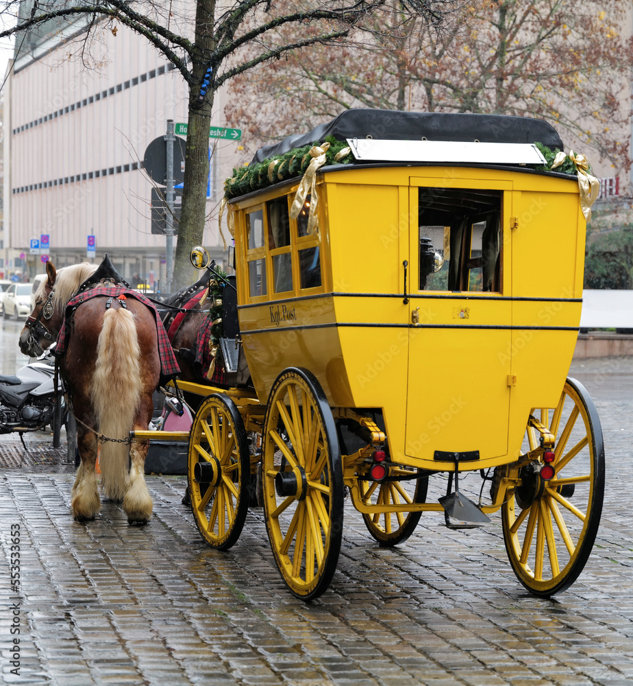 Historische gelbe Postkutsche von zwei Pferden gezogen in der Nürnberger Altstadt in der Vorweihnachtszeit 