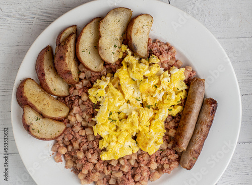 cramble eggs on corn beef hash with  sausage and potatoes, photo