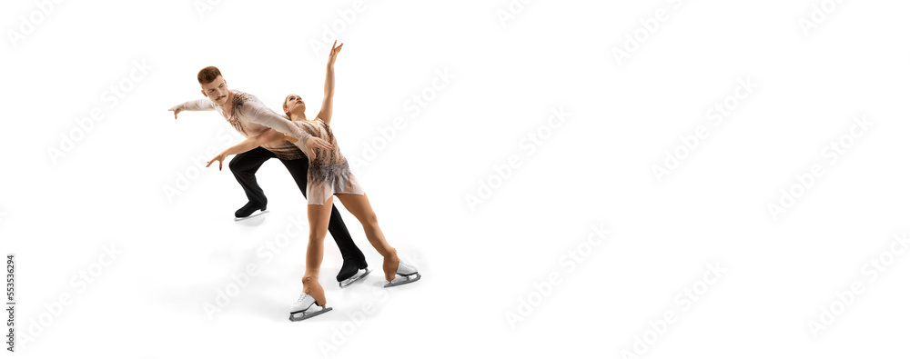 Portrait of young man and woman, figure skating athletes performing isolated over white studio background. Difficult techniques. Flyer
