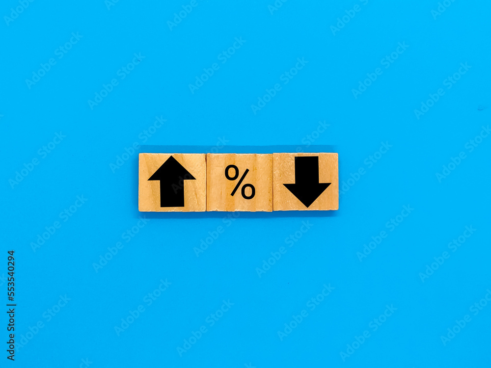 Percent symbols and arrows pointing up and down on them in a market, economy and price concept image. Blue background. Percent symbols and arrows pointing up and down on them in a market, economy and price concept image. Blue background.