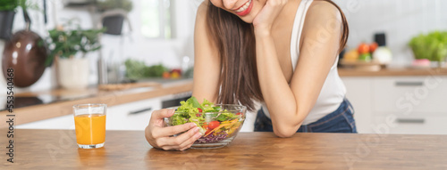 Diet, Dieting, smiling asian young woman, girl hand holding vegetables, green salad bowl on table at home, eat vegetarian food is low fat good healthy. Nutritionist weight loss for health person.