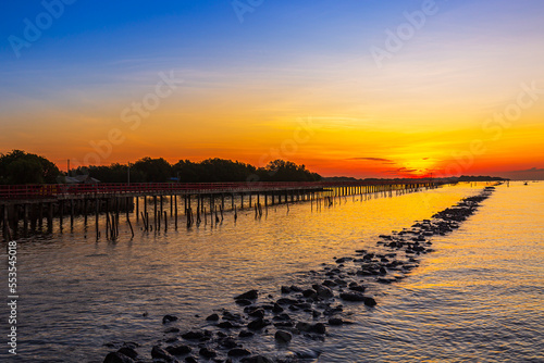 Sea coast and wooden bridge,View of wooden bridges and coastline at sunrise,Wooden bridge at the sea at sunset © banjongseal324