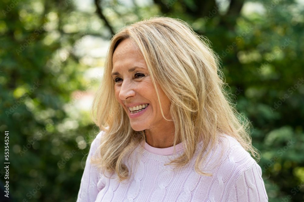 Portrait of middle aged woman smiling while enjoying time outdoors Portrait of middle aged woman smiling while enjoying time outdoors