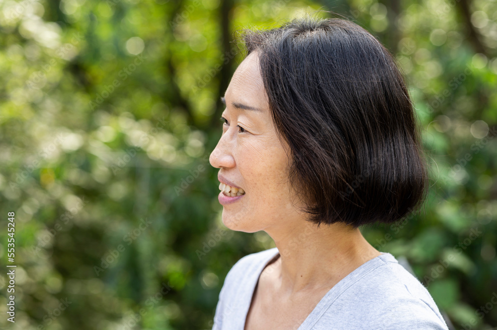 Side view shot of senior Asian-American woman standing outdoors Side view shot of senior Asian-American woman standing outdoors