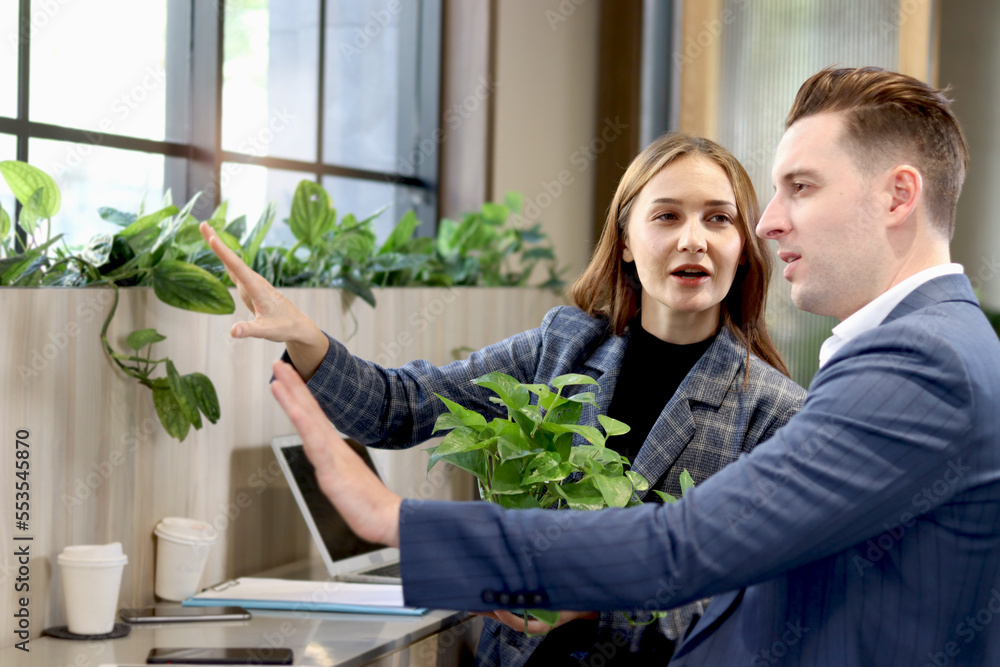 Happy colleague partner businessman and woman talking at lobby of modern office or coffee shop, attractive business people working together, having conversation and discussion about work project. Happy colleague partner businessman and woman talking at lobby of modern office or coffee shop, attractive business people working together, having conversation and discussion about work project.