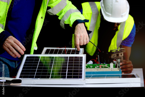 Two electrical engineers working with electronic circuit board and solar cells, mechanicals senior white and African American men working together, Happy diversity harmony people.