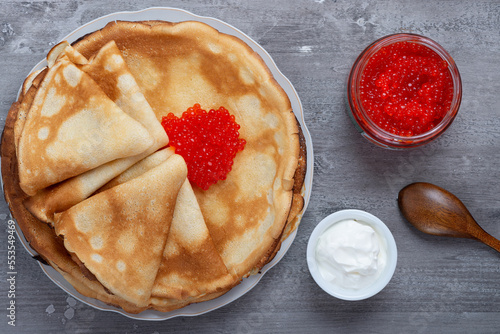 Tableau sur toile Stack of russian thin pancakes blini with red caviar and fresh sour cream