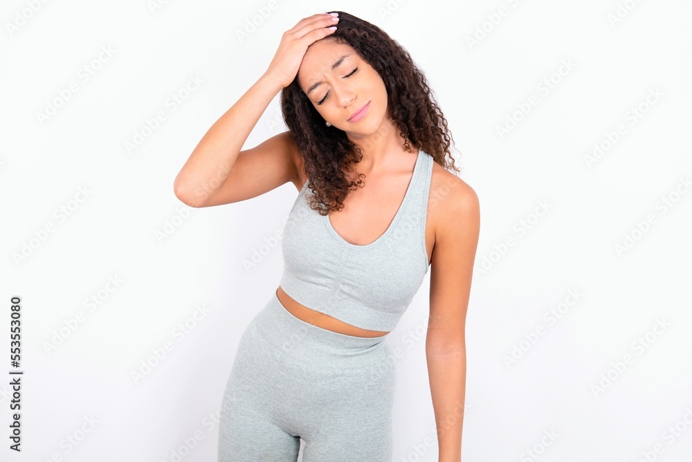 A very upset and lonely Beautiful teen girl with curly hair wearing grey sport set over white background crying, A very upset and lonely Beautiful teen girl with curly hair wearing grey sport set over white background crying,
