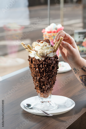 taça de sorvete lambuzada com pedaços de chocolate photo