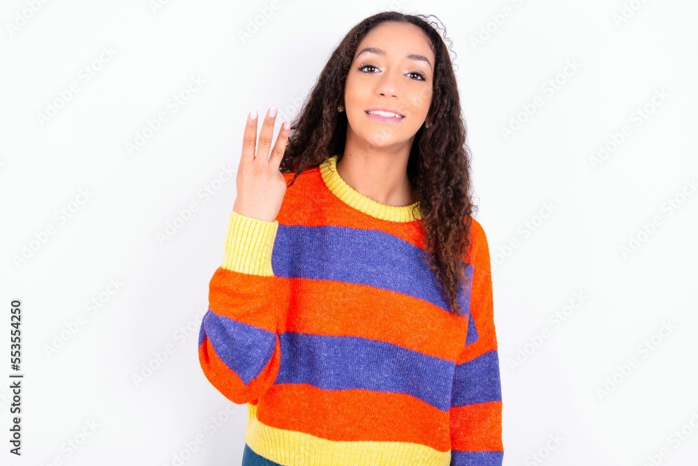 beautiful teen girl wearing striped knitted sweater over white background smiling and looking friendly, showing number three or third with hand forward, counting down beautiful teen girl wearing striped knitted sweater over white background smiling and looking friendly, showing number three or third with hand forward, counting down