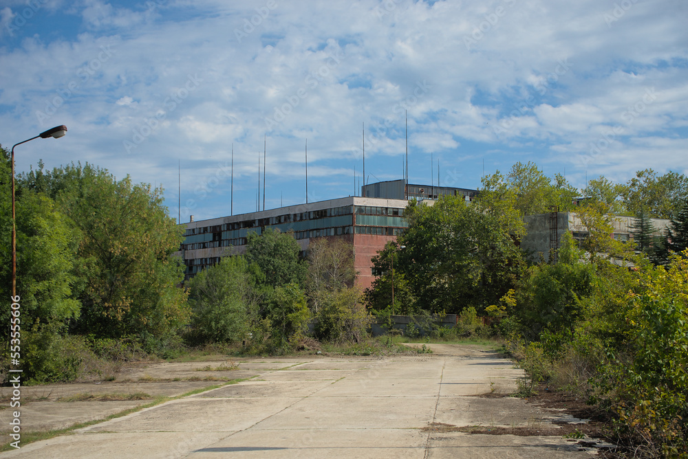 Abandoned industrial building overgrown with trees