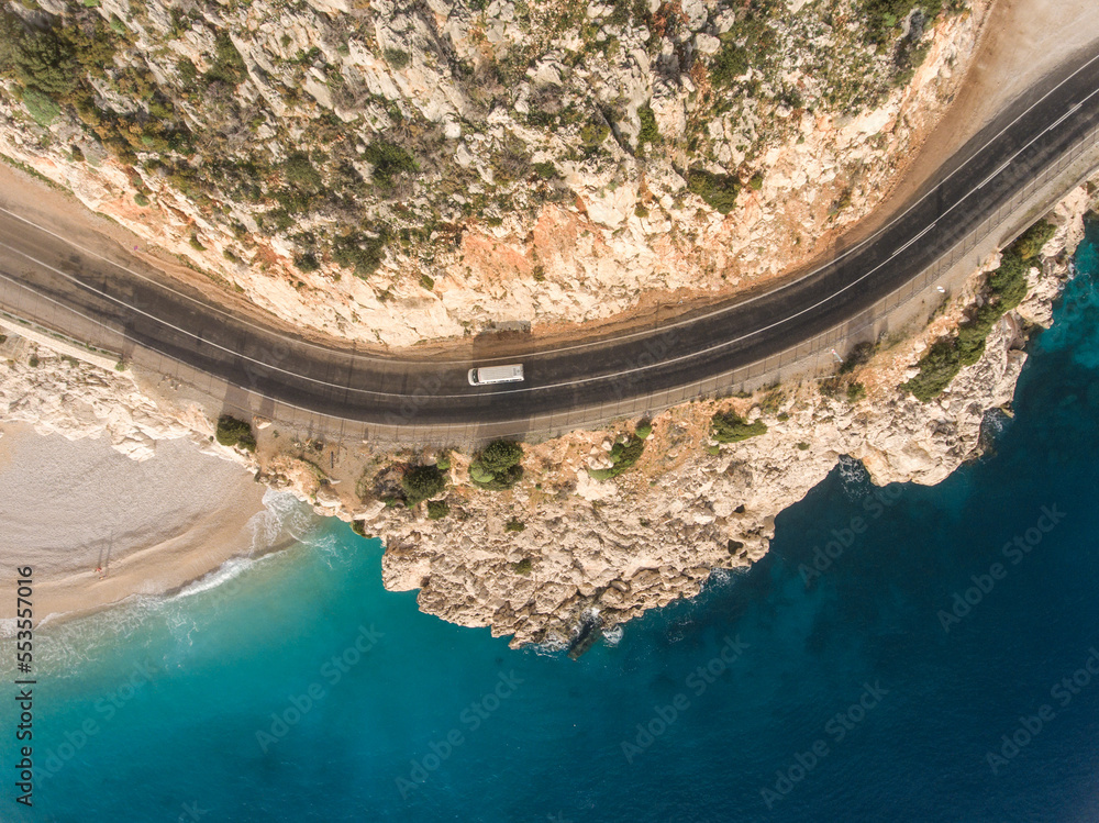 Fototapeta premium Top view of the road between the mountains and a secluded beach