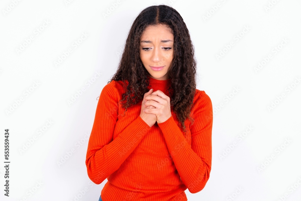 Sad teen girl wearing knitted red sweater over white background feeling  upset while spending time at home alone staring at camera with unhappy or  regretful look. Stock Photo | Adobe Stock