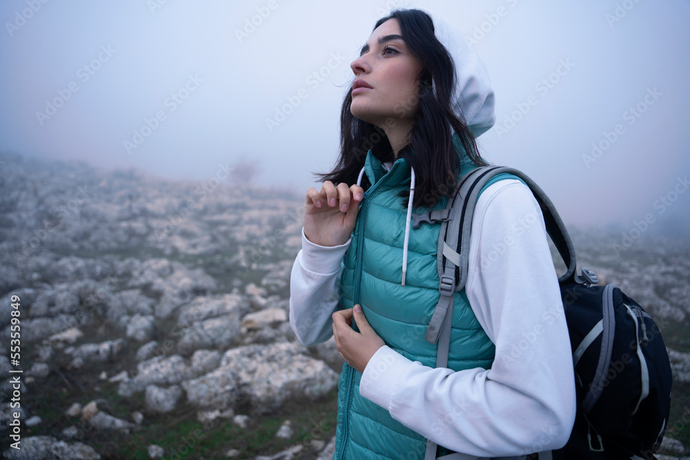 Female hiker with backpack travel in foggy mountains Female hiker with backpack travel in foggy mountains
