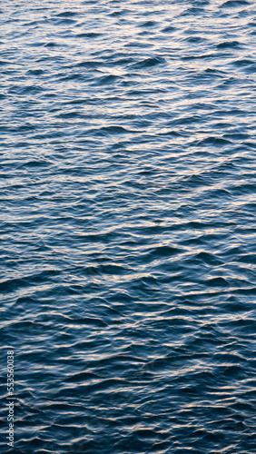 Superficie del agua con oleaje del oceano al atardecer photo
