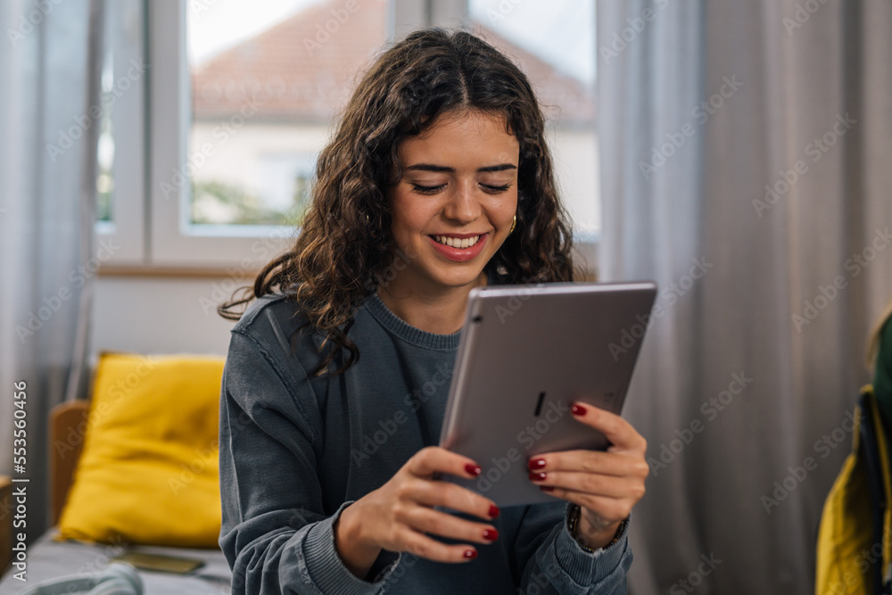 Fototapeta premium Front view of a brunette college student studying in a dorm room