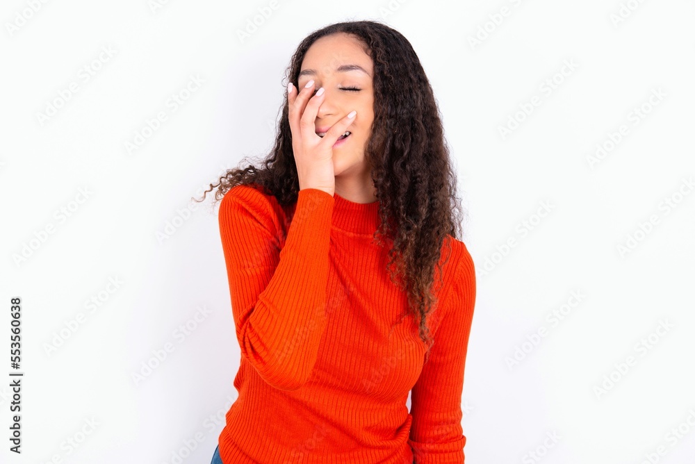 Charismatic carefree joyful teen girl wearing knitted red sweater over white background likes laugh out loud not hiding emotions giggling hear funny hilarious joke chuckling facepalm. Charismatic carefree joyful teen girl wearing knitted red sweater over white background likes laugh out loud not hiding emotions giggling hear funny hilarious joke chuckling facepalm.
