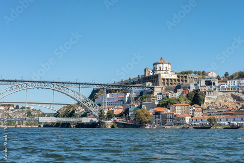 Partial view of the impressive Dom Luise I arch bridge connecting the historic district Ribeira and Vila Nova de Gaia neighborhood as seen from Douro River waters in Porto, Porgual © Ana