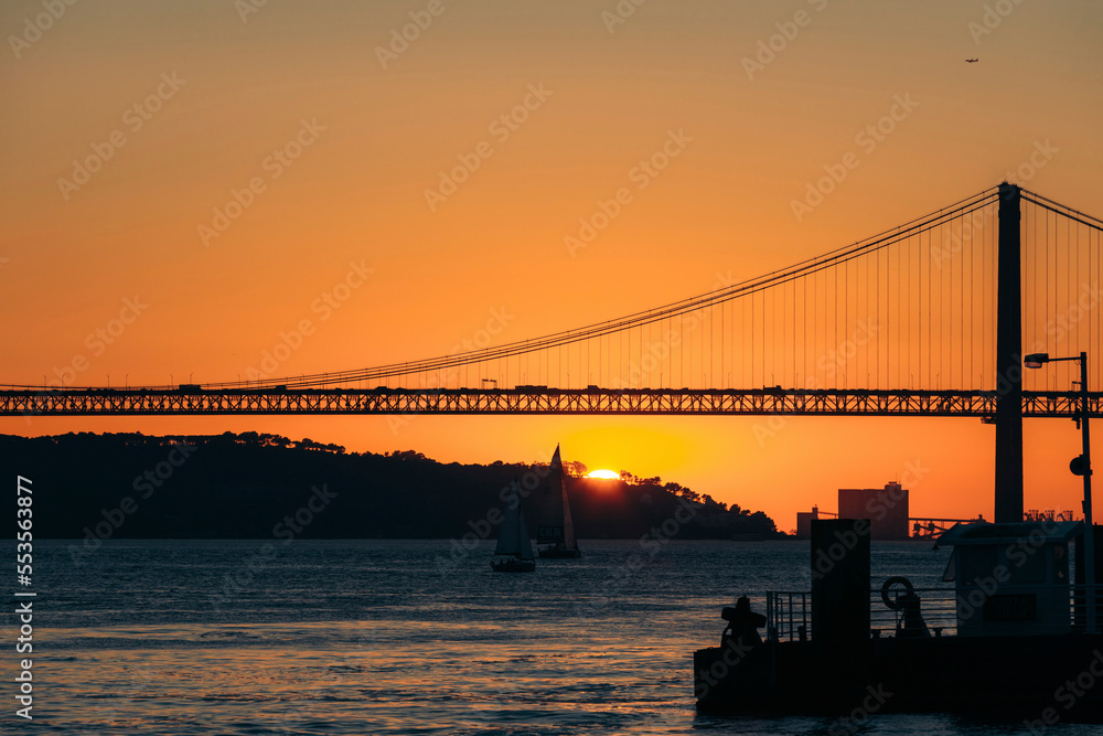 Silhouette of the 25 de Abril Bridge crossing the Tagus River, connecting Lisbon and Almada at sunset; Lisbon, Estremadura, Portugal Silhouette of the 25 de Abril Bridge crossing the Tagus River, connecting Lisbon and Almada at sunset; Lisbon, Estremadura, Portugal