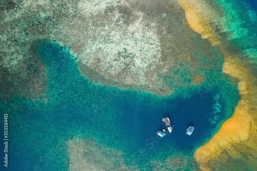 View taken from directly above of boats anchored in an off shore lagoon in Komodo National Park with a sandbar and turquoise coastal water; East Nusa Tenggara, Lesser Sunda Islands, Indonesia