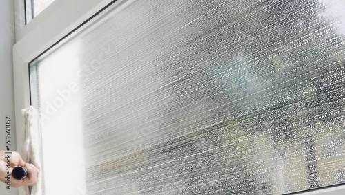 A professional cleaning service worker washes the windows with special foam and cleans them.