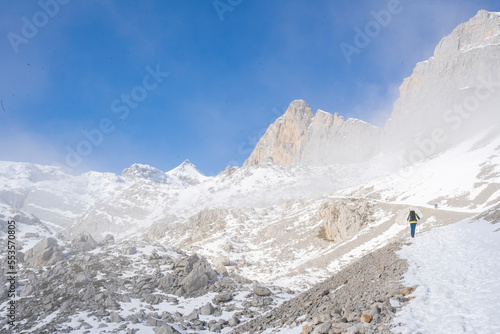 alpinist clibing a snowy mountain in winter