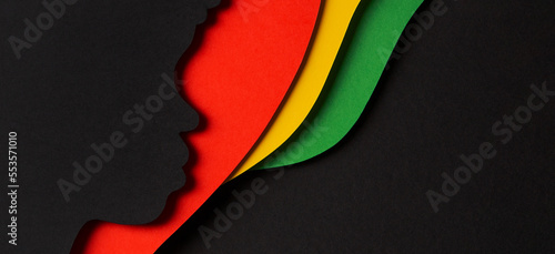 Black History Month color background. African Americans history celebration. Abstract geometric red, yellow, green color background with black paper cut people silhouette. Top view