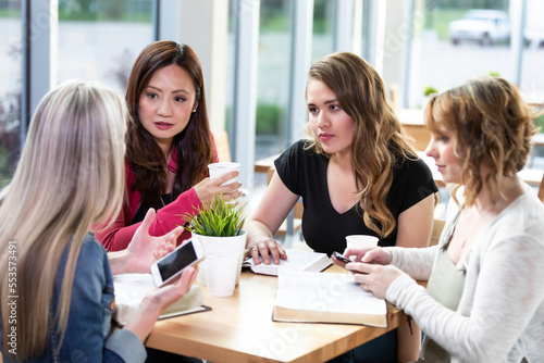 A group of women gathered together for a Bible study in a coffee shop at a church; Edmonton, Alberta, Canada photo