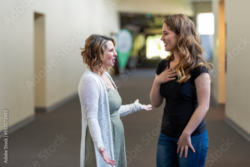 A young woman and her youth leader discussing their faith in a hallway of a church: Edmonton, Alberta, Canada photo