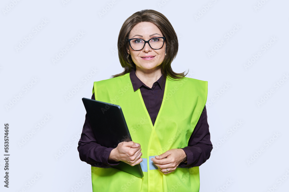 Portrait of engineer manager woman in vest holding laptop